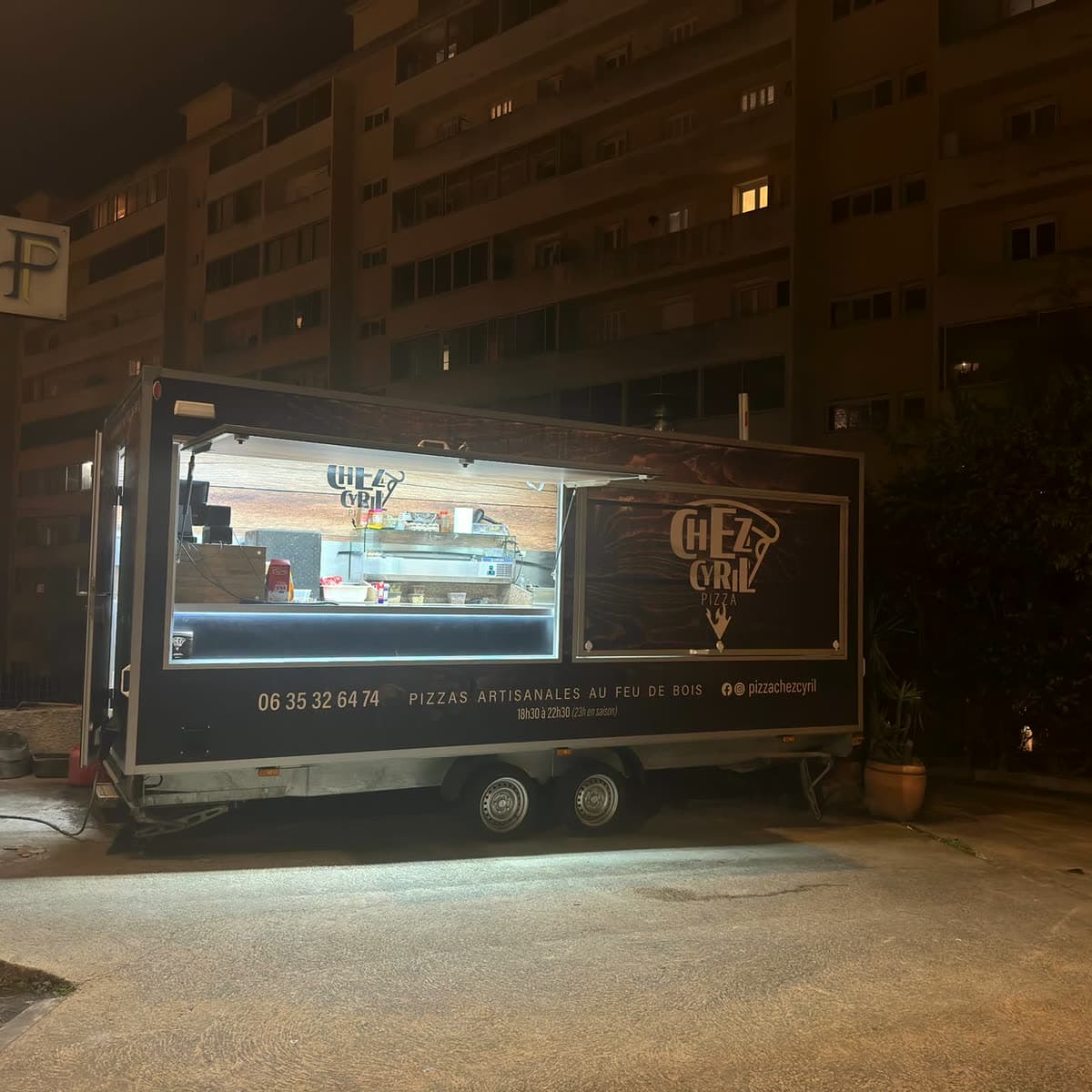 Le camion à pizza Chez Cyril, éclairé de nuit à Ajaccio